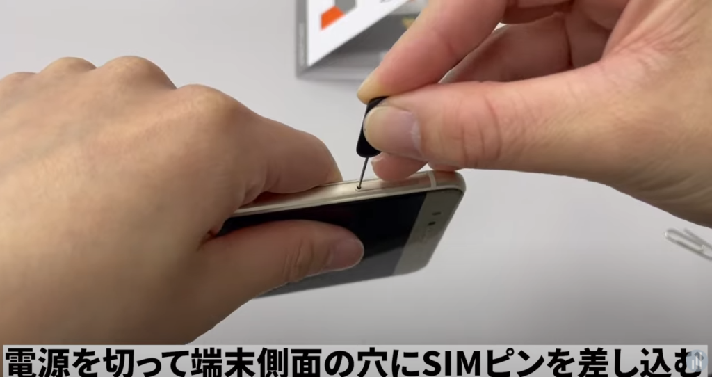 端末側面の穴にSIMピンを差し込む